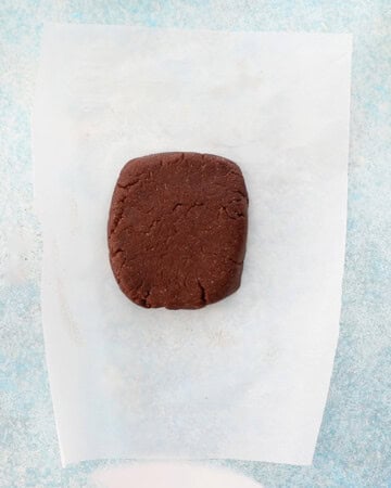 brown almond flour chocolate cookie dough on a white paper.