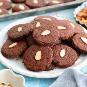 brown almond chocolate cookies on a white plate.